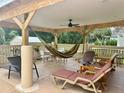 Relaxing covered patio with comfortable seating, ceiling fan, and beautiful wooden beams, ideal for outdoor enjoyment at 3501 Pine Top Dr, Valrico, FL 33594