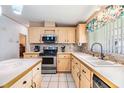 Well-lit kitchen with stainless steel appliances, granite countertops, and tiled floors at 36731 Tara Ave, Zephyrhills, FL 33542