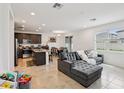 Open-concept living space with gray couch, dining area, and modern kitchen with stainless appliances at 37820 Beacon Brick Dr, Zephyrhills, FL 33540