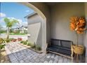Inviting porch with a black bench, decorative plants, and a brick paver walkway leading to the street at 37820 Beacon Brick Dr, Zephyrhills, FL 33540