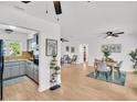Open-concept living area with sleek wood floors, modern lighting, and inviting dining area at 410 N Corona Ave, Clearwater, FL 33765