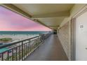 Balcony view of beach from condo hallway during a vibrant sunset at 4510 Gulf Blvd # 604, St Pete Beach, FL 33706