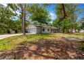 Exterior showcasing the home's side, garage, long driveway, and mature trees at 605 Ronele Dr, Brandon, FL 33511