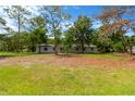 Single-story home with a spacious front lawn surrounded by mature trees and natural beauty at 605 Ronele Dr, Brandon, FL 33511