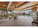 Bright sunroom with wood ceiling, brick floors, and many windows overlooking the pool and waterfront at 648 Geneva Pl, Tampa, FL 33606