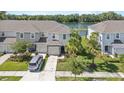 Attractive townhouse with lush landscaping, palm trees, and a serene lake view at 7916 Evergreen Creek Ct, Riverview, FL 33578