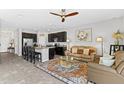 Open-concept living area with a ceiling fan flowing into the kitchen with a breakfast bar at 7916 Evergreen Creek Ct, Riverview, FL 33578
