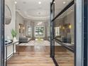 Welcoming foyer with hardwood floors, a modern chandelier, and views of the serene outdoors at 9712 Tree Tops Lake Rd, Tampa, FL 33626
