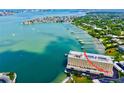 Aerial view showcasing a waterfront condo complex with multiple boat slips on a picturesque bay at 100 Bluff View Dr # 115C, Belleair Bluffs, FL 33770