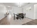 Dining room featuring a dining table with chairs, modern chandelier, and hardwood floors at 11434 Leland Groves Dr, Riverview, FL 33579