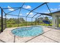 Screened-in pool area featuring an in-ground pool, spa, and an umbrella for sunbathing at 11434 Leland Groves Dr, Riverview, FL 33579