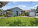 Beautiful single-story home with landscaped yard, featuring a blue exterior and well-maintained lawn at 12546 108Th St, Largo, FL 33778