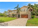 Elegant two-story home featuring a paver driveway, lush lawn, and a spacious two-car garage at 131 Miramar Ne Blvd, St Petersburg, FL 33704