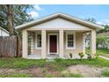 Charming home with a front porch, windows, and a striking red front door at 14935 Julian St, Dade City, FL 33523