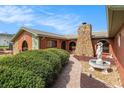 Quaint house exterior featuring unique stone accents, lush greenery, a decorative fountain, and a charming walkway to the entrance at 159 Canby Cir, Spring Hill, FL 34606