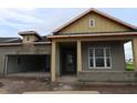 Unfinished exterior elevation of a new home with an attached garage and covered entryway awaiting finishing touches at 1614 Running Tide Pl, Sarasota, FL 34240