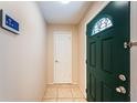 Welcoming entryway featuring a green front door, light tile flooring, and a smart home system on the wall at 2020 58Th N Way, Clearwater, FL 33760