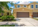 Charming townhome with a two-car garage, framed by lush landscaping and a well-maintained lawn at 2022 Hawks View Dr, Ruskin, FL 33570