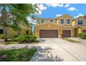 Attractive townhome with a two-car garage, situated in a well-kept neighborhood and complemented by greenery at 2022 Hawks View Dr, Ruskin, FL 33570
