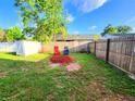 This backyard offers a cozy fire pit area with rustic wood fencing and lush green grass at 22798 Penny Loop, Land O Lakes, FL 34639
