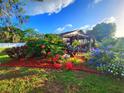 Lush landscaping surrounds this charming home with a cozy gazebo and vibrant floral accents at 22798 Penny Loop, Land O Lakes, FL 34639