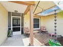 Cozy covered porch with a seating area, decorative rain chain, and view of front entrance at 2714 Witley Ave, Palm Harbor, FL 34685