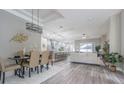Bright, open-concept living space with modern lighting, wood floors, and a connected kitchen at 2957 Hickory Grove Dr, Valrico, FL 33596