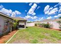 Large, well-maintained backyard with lush grass, a white fence, and a covered patio area at 31349 Philmar Ln, Wesley Chapel, FL 33543