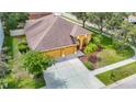 Bird's-eye view of home with a large driveway, two-car garage, mature landscaping, and inviting entryway at 3824 Duke Firth St, Land O Lakes, FL 34638