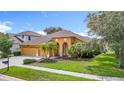 Charming single-story home featuring a well-manicured lawn, arched entryway, and a two-car garage at 3824 Duke Firth St, Land O Lakes, FL 34638