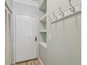 Entryway features a white door, coat hooks, a small storage nook, and wood-look floors for added functionality at 4207 S Dale Mabry Hwy # 2105, Tampa, FL 33611