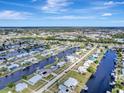 Scenic aerial view of a waterfront community with canals and neatly arranged homes under a bright blue sky at 551 Lindley Ter, Port Charlotte, FL 33952