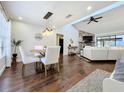 Bright dining area featuring wood floors and elegant light fixture open to a cozy living room at 6682 Mauna Loa Blvd, Sarasota, FL 34241