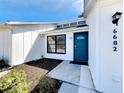Inviting home featuring a vibrant blue front door and beautifully landscaped entryway at 6682 Mauna Loa Blvd, Sarasota, FL 34241