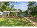 A charming single-story home showcases a well-manicured lawn and bright blue front door at 7219 4Th N Ave, St Petersburg, FL 33710