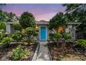 Charming home front featuring a bright blue door framed by well-manicured trees at 7219 4Th N Ave, St Petersburg, FL 33710