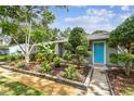 Inviting single-story home with a colorful front garden and a bright blue door at 7219 4Th N Ave, St Petersburg, FL 33710