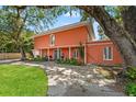 A stunning view of the two-story home showcasing the manicured lawn, mature trees, and spacious driveway at 817 S West Shore Blvd, Tampa, FL 33609