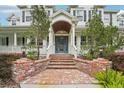 Elegant entryway with brick steps, covered entrance, and updated blue door at 8410 Kenavis Pl, Odessa, FL 33556