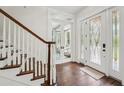 Bright foyer with hardwood floors, staircase, and decorative glass front door at 8410 Kenavis Pl, Odessa, FL 33556