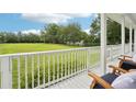 Inviting porch view showcasing outdoor seating and expansive green lawn at 8410 Kenavis Pl, Odessa, FL 33556