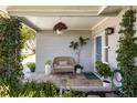 Inviting front porch with cozy seating, lush greenery, and charming decor, creating a welcoming entrance at 10095 Oakhurst Rd, Seminole, FL 33776