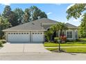 Charming home featuring a well-manicured lawn, mature trees, and a three-car garage at 10751 Tavistock Dr, Tampa, FL 33626