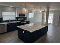 Modern kitchen with a large island, stainless steel appliances, and stylish pendant lighting at 11110 1St E St, Treasure Island, FL 33706