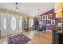 Elegant dining room features a modern chandelier, stylish decor, and a colorful area rug on hardwood floors at 13238 Asbury St, Spring Hill, FL 34609