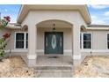 Inviting front entrance with decorative door, overhead lighting, and beautiful tiled entryway under an arched portico at 13238 Asbury St, Spring Hill, FL 34609