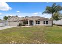 Charming single-story home featuring a well-maintained lawn, lush landscaping, and a spacious two-car garage at 13238 Asbury St, Spring Hill, FL 34609