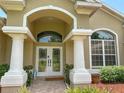 Welcoming front entrance features grand columns, arched entryway, and glass double doors at 13807 Eagles Rock Ct, Hudson, FL 34667