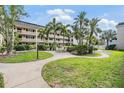 A serene outdoor space features lush greenery, winding sidewalks, and tables with chairs for residents at 147 Bluff View Dr # 105, Belleair Bluffs, FL 33770