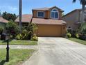 Inviting two-story home boasts a two car garage and vibrant landscaping at 1855 Briland St, Tarpon Springs, FL 34689